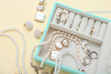 Soluk sarı arka planda şık mücevherleri olan organizatör