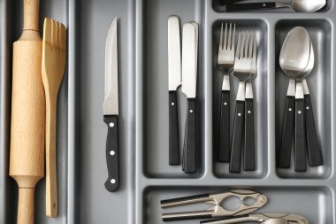 Farklı gümüş çatal bıçaklarla mutfak çekmecesini aç