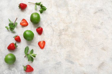 Limonlu taze çilek ve gri arka planda nane.