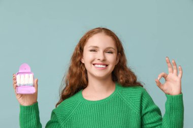 Tampon saklama kutusu olan güzel genç bir kadın mavi arka planda güzel bir jest gösteriyor.