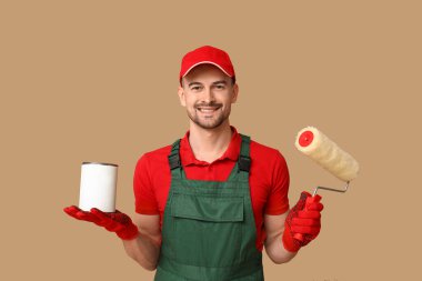 Erkek ressamın silindirli portresi ve bej arka planda boya kutusu.