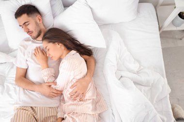 genç bir çift yatakta yatıyor.