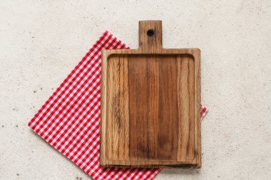 Ahşap tahta ve bej grunge arkaplan üzerinde kırmızı kareli peçete ile masa ayarı