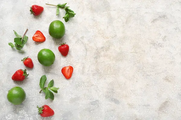Limonlu taze çilek ve gri arka planda nane.