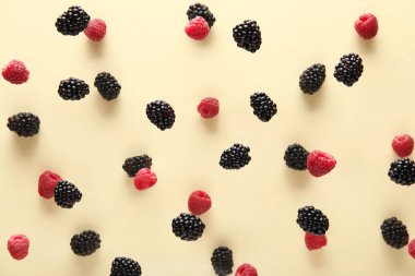 Bej arka planda uçuşan böğürtlen ve ahududu, yakın plan