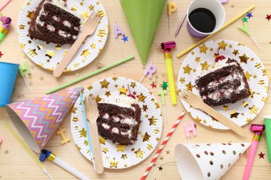 Lezzetli doğum günü pastası tabakları ve ahşap arka planda doğum günü partisi için dekorasyon.