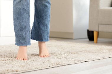 Mutfakta yumuşak halıda çıplak ayaklı kadın, yakın plan.