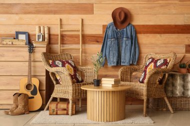 Oturma odası, koltuklar, kot ceket ve kovboy şapkası.