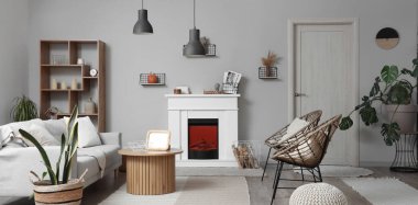 İçinde şömine, gri kanepe ve sandalyeler olan modern oturma odası.