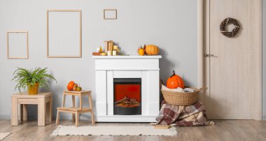 Şömineli ve sonbahar balkabaklı aydınlık oturma odasının içi.