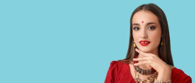 Açık mavi arka planda sari giymiş güzel Hintli genç bir kadın ve metin için yeri var.