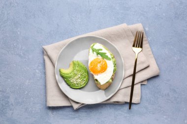 Gri arka planda avokado ve yumurta ile lezzetli bruschetta tabağı.