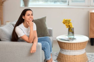 Evdeki kanepede rüya gören genç bir kadın.