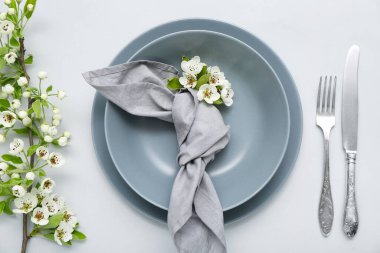 Gri arkaplanda çiçek açan ağaç dalları olan güzel masa ayarları