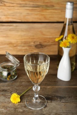 Ahşap masada bir şişe karahindiba şarabı.