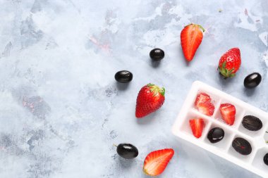 Mavi arka planda taze ve donmuş dutlu buz tepsisi