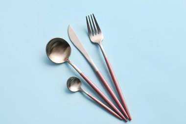 Mavi arkaplanda şık çatal bıçak takımı