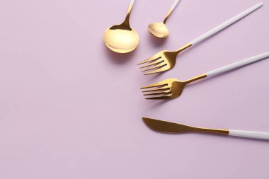 Pembe arka planda şık çatal bıçak takımı