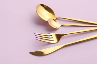 Pembe arka planda şık çatal bıçak takımı