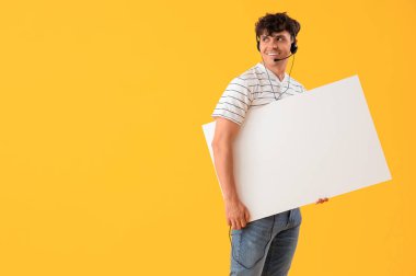 Sarı arka planda boş posteri olan erkek teknik destek ajanı