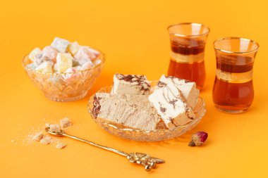 Lezzetli mermer helva parçaları ve turuncu arka planda Türk çayı.