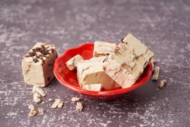 Arkaplanda lezzetli mermer helva parçaları olan bir kase.