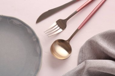 Beyaz zemin üzerinde paslanmaz çelik çatal bıçak takımı olan plaka.