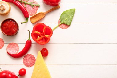 Açık ahşap arka planda pizza hazırlamak için farklı malzemeler.