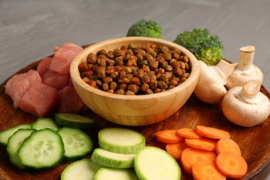 Kuru hayvan mamasıyla kase, çiğ et ve doğal ürünler, yakın plan.