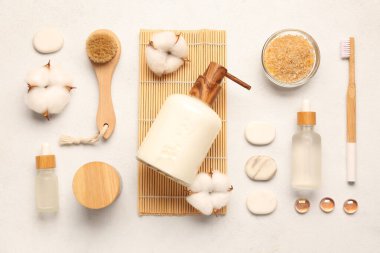 Kozmetik ürünlerle, banyo malzemeleriyle ve arka planda pamuk çiçekleriyle kompozisyon