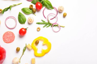 Beyaz arkaplanda pizza hazırlamak için gerekli malzemeler