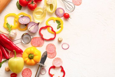 Beyaz arkaplanda pizza hazırlamak için gerekli malzemeler