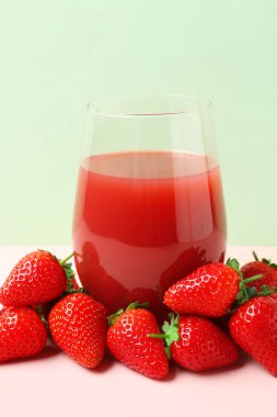 Beyaz masada bir bardak lezzetli çilek suyu.