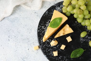 Lezzetli İsviçre peyniri ve hafif arka planda üzümlü tahta