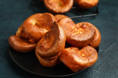 Mavi arka planda lezzetli Yorkshire pudingi olan tabak.