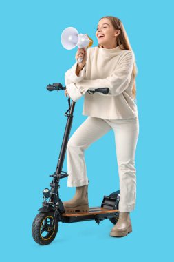 Mavi arka planda elektrikli scooterlı genç bir kadın megafona bağırıyor.