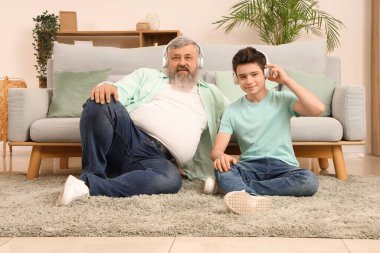 Mutlu büyükbaba ve sevimli torunu evde müzik dinliyor.