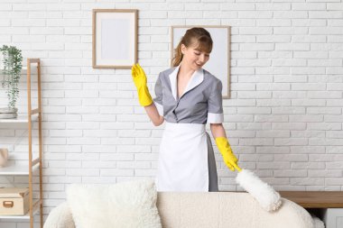 Oturma odasındaki el temizleme koltuğuyla gülümseyen hizmetçi.