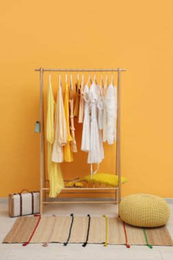 Sarı duvarın yanında kadın kıyafetleriyle dizilin.