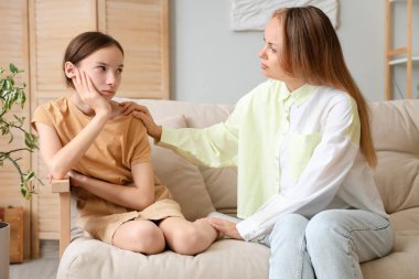 Annesi evdeki kanepede oturan üzgün genç kız. Aile sorunları kavramı