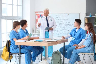 Üniversitede tıp öğrencilerine ders veren olgun bir doktor.