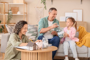 Evde para kavanozları olan mutlu bir aile.