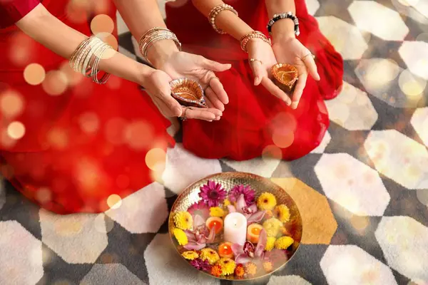 stock image Indian woman and her daughter with candles, flowers and diya lamps at home. Divaly celebration