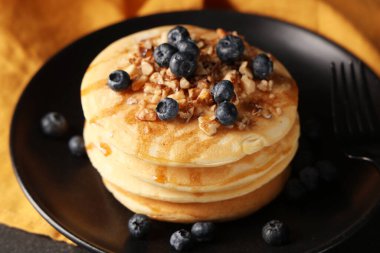 Siyah arka planda taze yaban mersinli ve fındıklı tatlı gözleme tabağı, yakın plan.