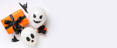 Komik Cadılar Bayramı balonları, hediye kutuları ve beyaz arka planda kağıt hayaletler.