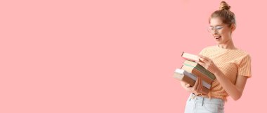 Mutlu kız öğrenci pembe arkaplan üzerine kitap yığını tutuyor ve metin için yer var.