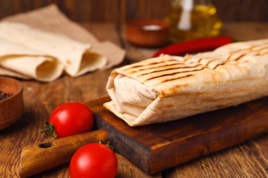 Tahta masadaki domatesli lezzetli shawarma.
