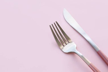 Pembe arka planda paslanmaz çelik çatal ve bıçak