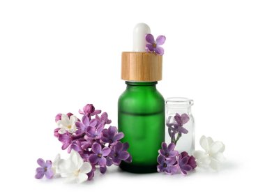 Beyaz arka planda güzel leylak çiçekleri olan kozmetik yağı şişeleri.