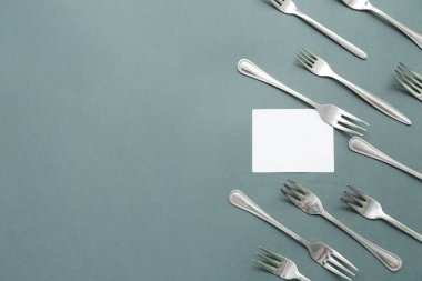 Renk arkaplan üzerinde paslanmaz çelik çatal ve boş kart bileşimi